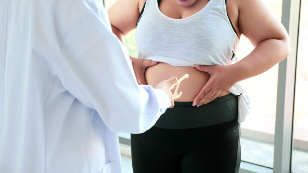 Médico medindo a barriga da paciente.